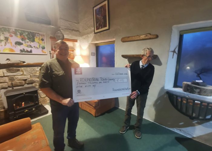 Noel Thompson of RoundstoneForFun presents a cheque for €18,105 to Richard de Stacpoole representing Roundstone Council.